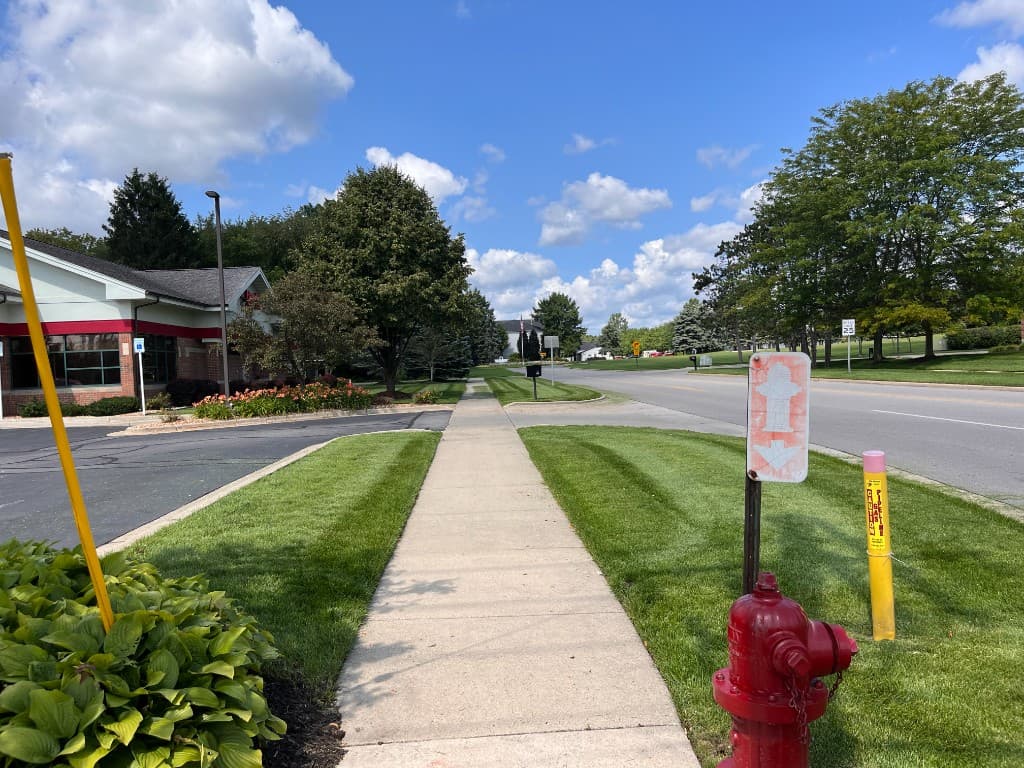 Well-maintained commercial property with manicured lawn and beds along a sidewalk