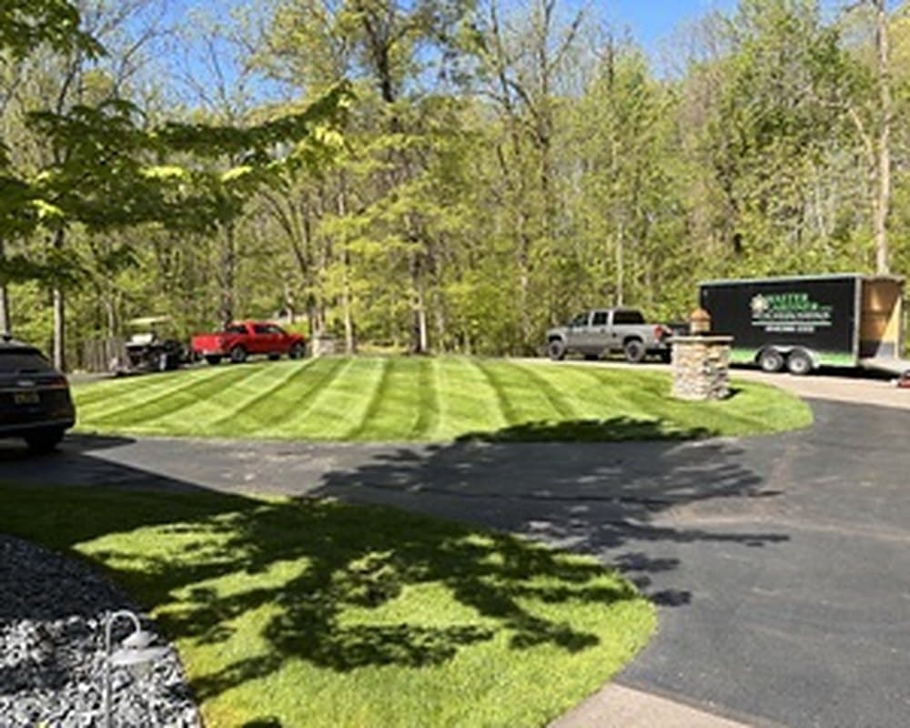 Master Gardner truck and equipment trailer staged on a property during a project