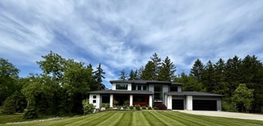Modern home set behind a wide, freshly striped lawn